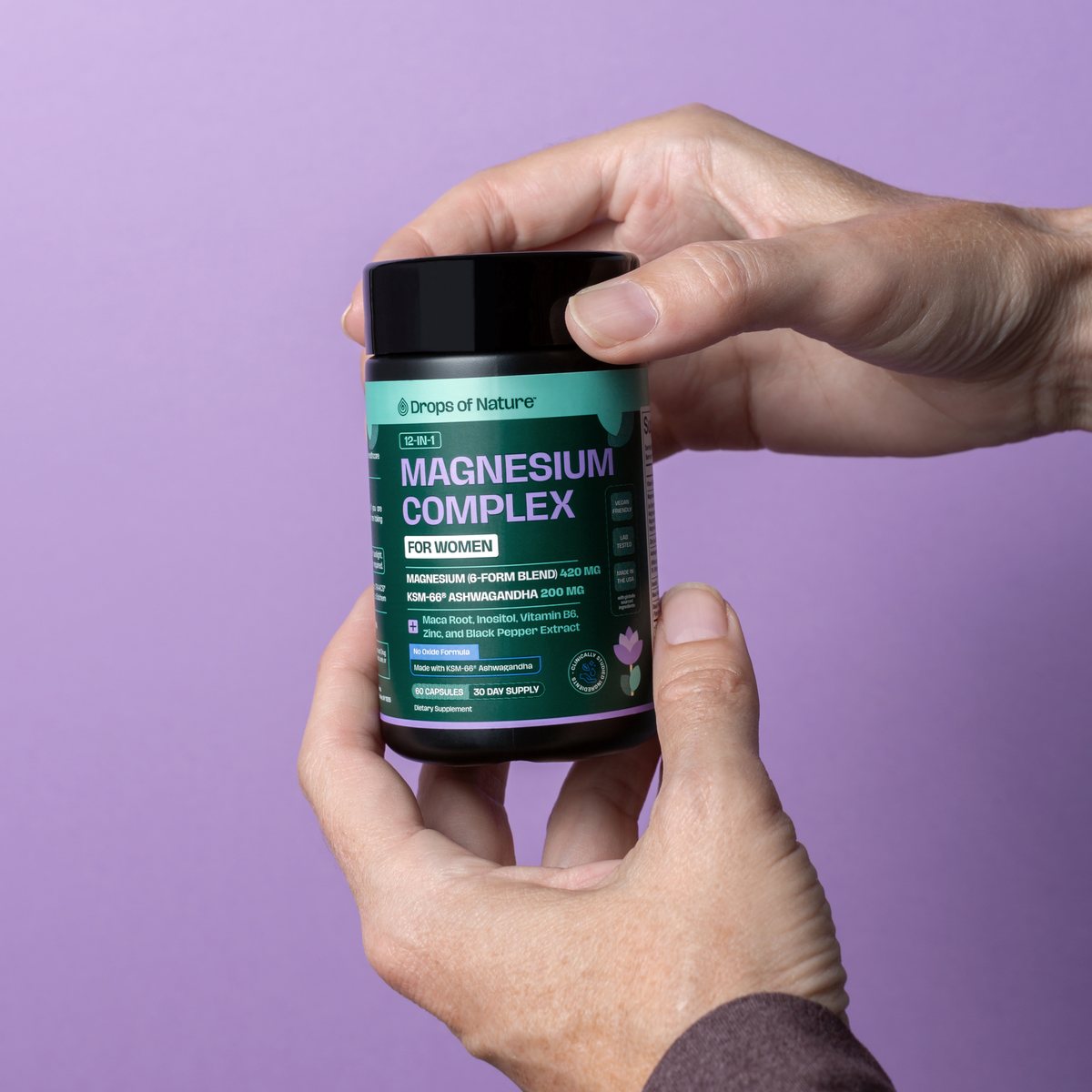 Hands holding a bottle of Magnesium Complex for Women.