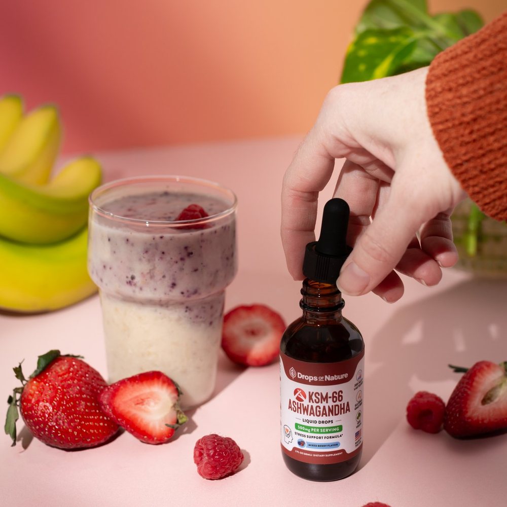 KSM-66 Ashwagandha bottle beside a pink berry smoothie.
