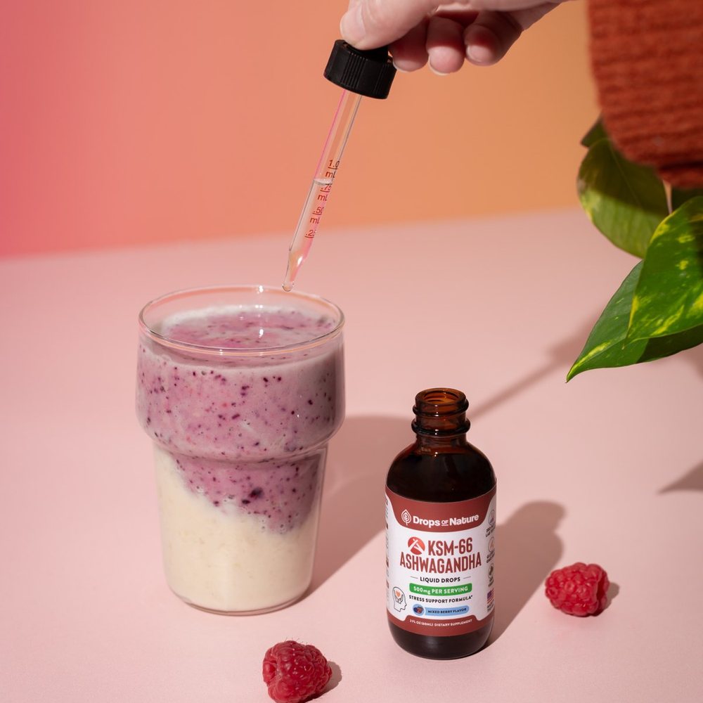 A dropper of KSM-66 Ashwagandha going into a pink smoothie.