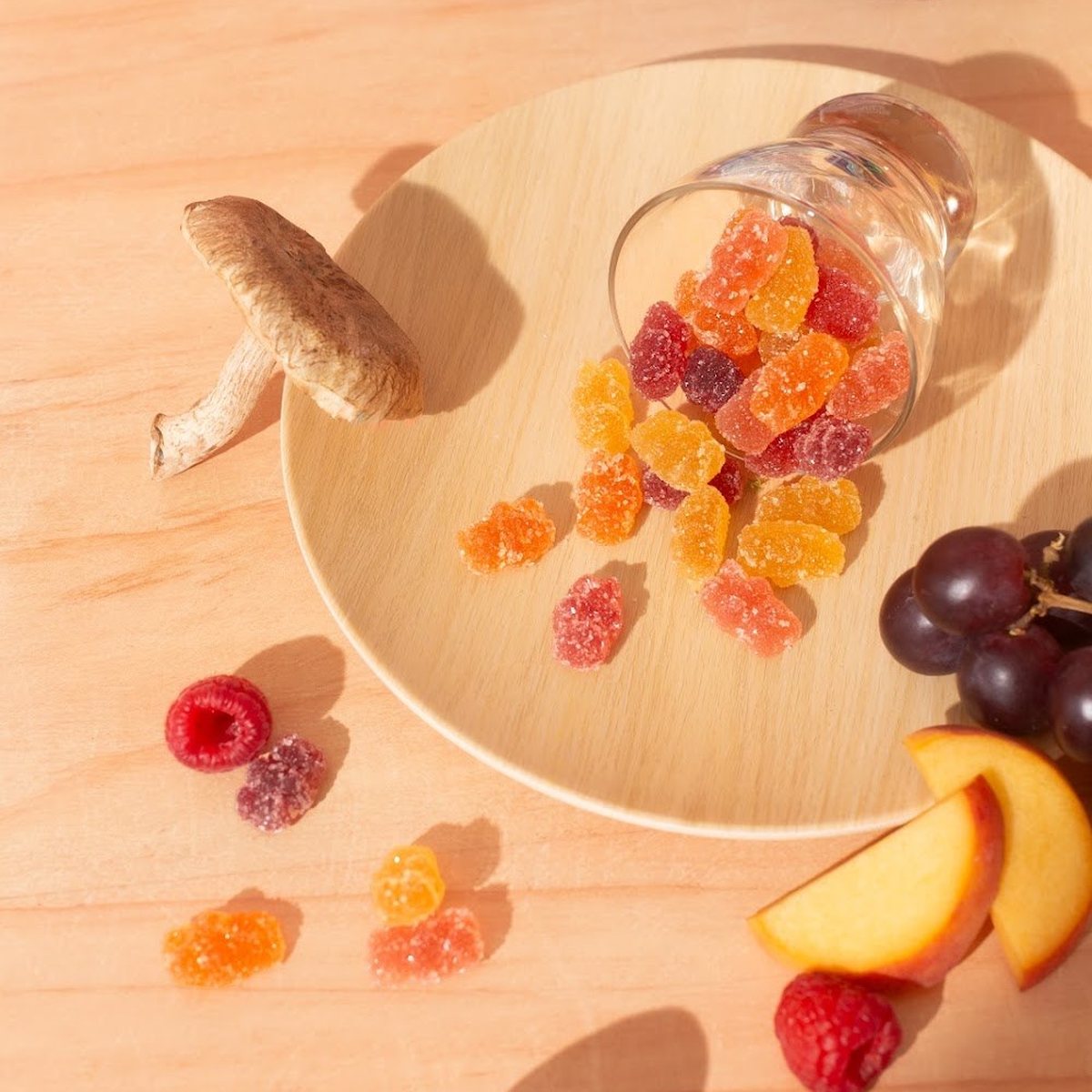 Gummy bears and fresh mushrooms around the bag, from above.