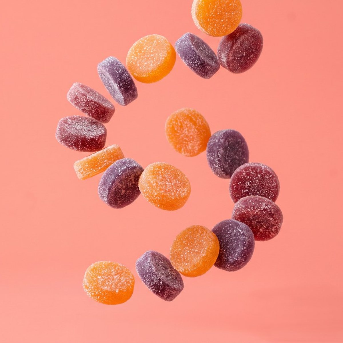 Big round mushroom gummies falling on a coral backdrop.