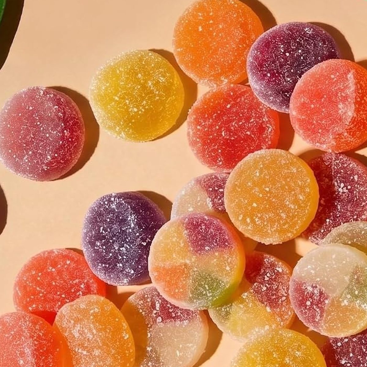 A pile of big round mushroom gummies in mixed fruit colors.