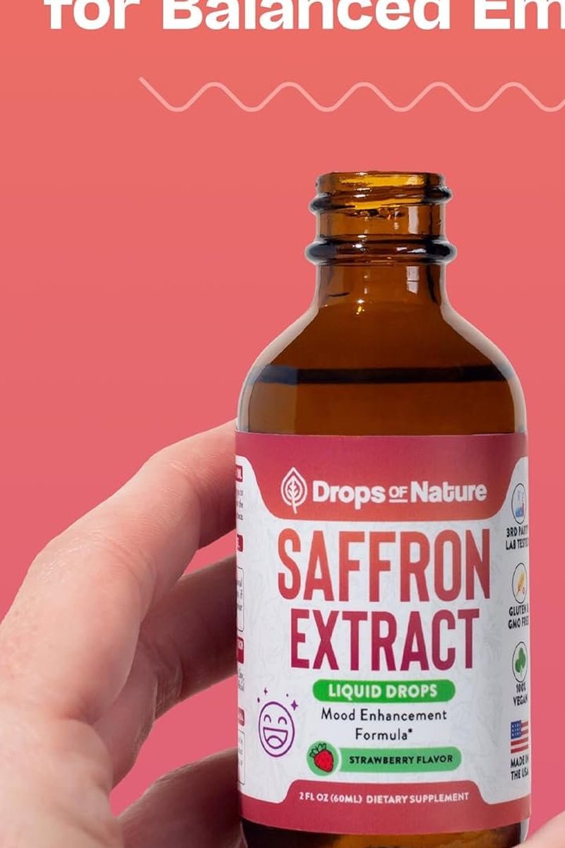 A hand holding a bottle of Saffron Extract drops.
