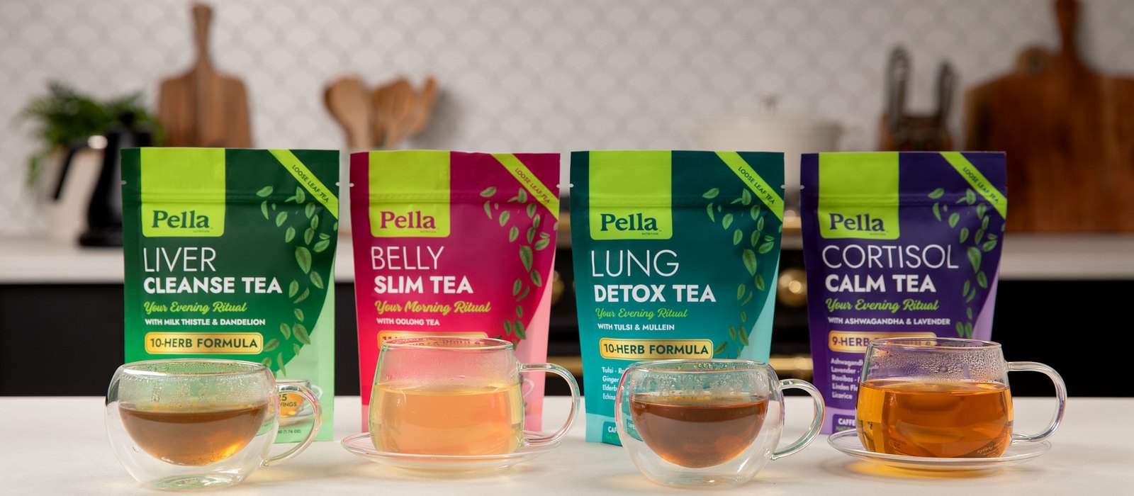 All four Pella loose-leaf tea pouches, Lung Detox, Belly Slim, Cortisol Calm and Liver Cleanse, each with a cup of brewed tea