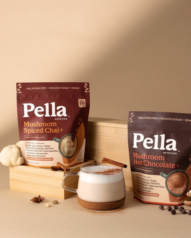 The Spiced Chai and Hot Chocolate bags beside a chai latte in warm evening light
