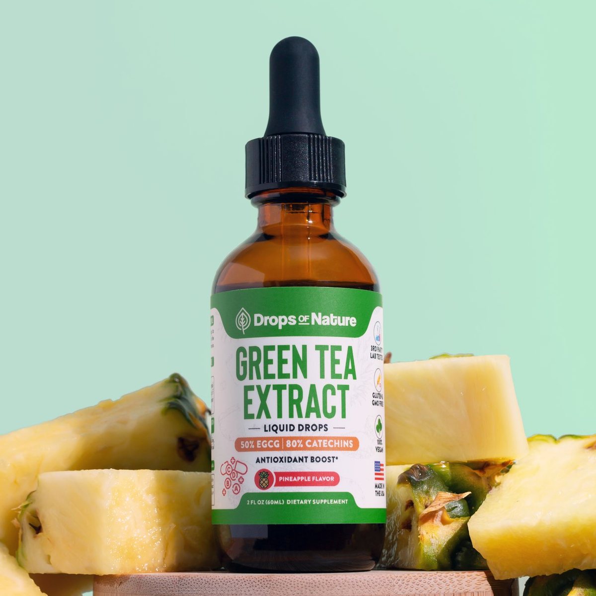 Drops of Nature Green Tea Extract liquid drops on a wooden block with pineapple