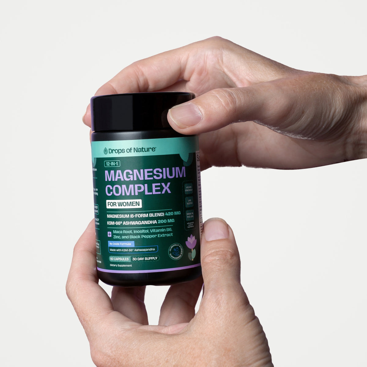 Hand holding a bottle of 12-in-1 Magnesium Complex for Women