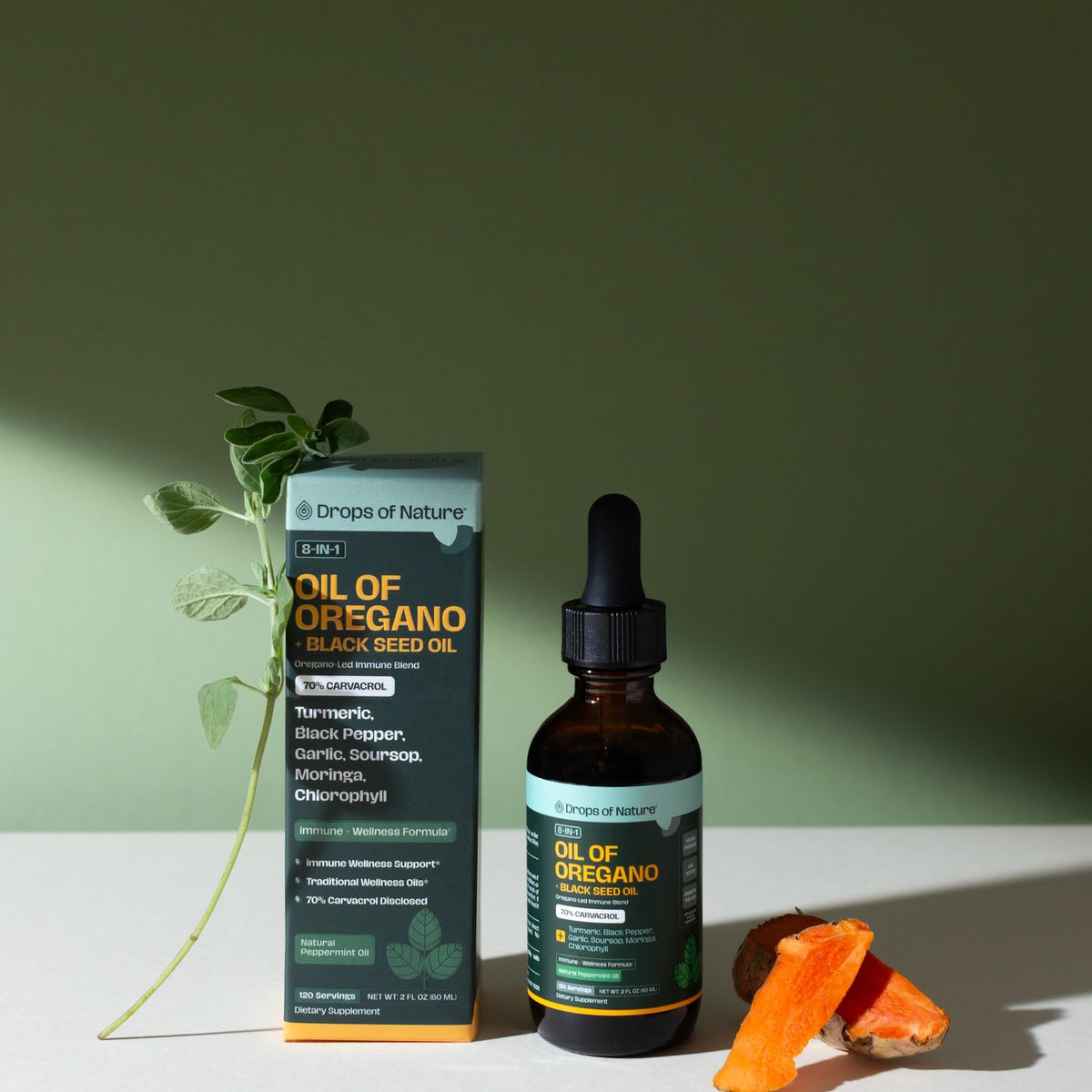 Oil of Oregano box and bottle beside oregano and turmeric root.