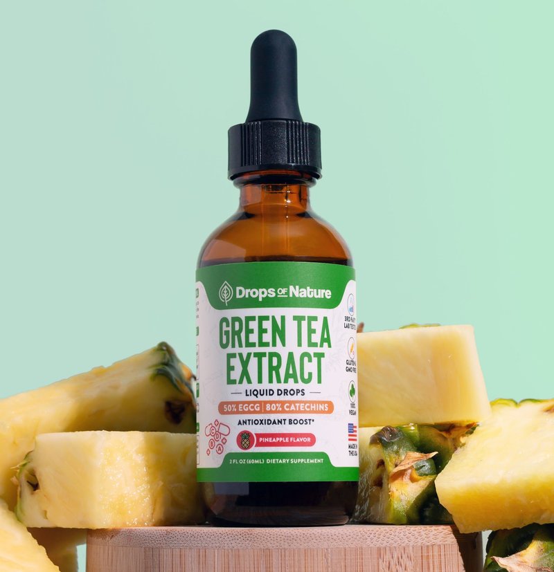 Green Tea Extract liquid drops bottle on a wooden block with pineapple