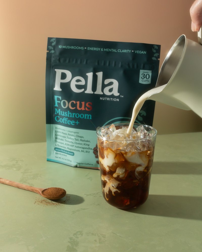 Milk being poured into an iced Focus mushroom coffee, next to the Focus bag